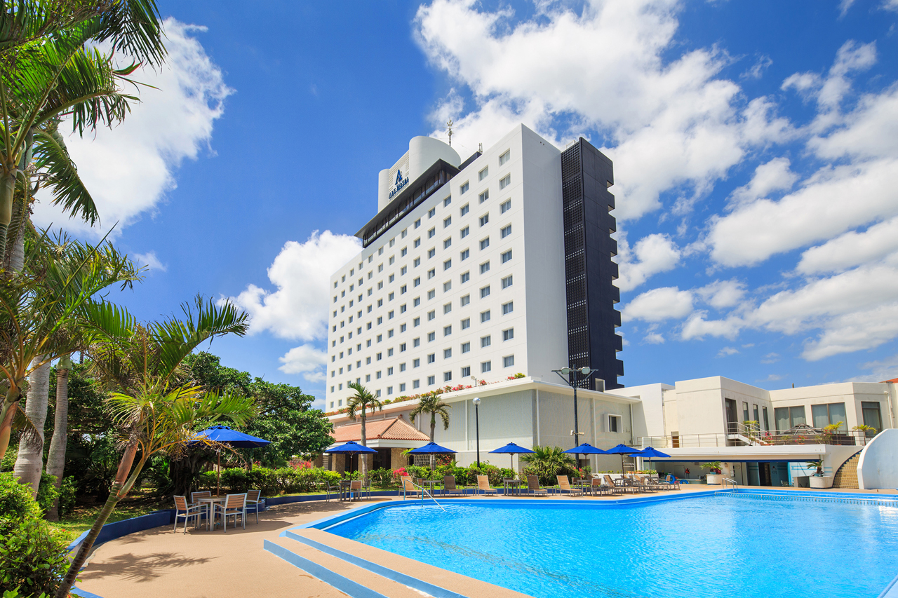 hotel, blue swimming pool, blue sky with clouds