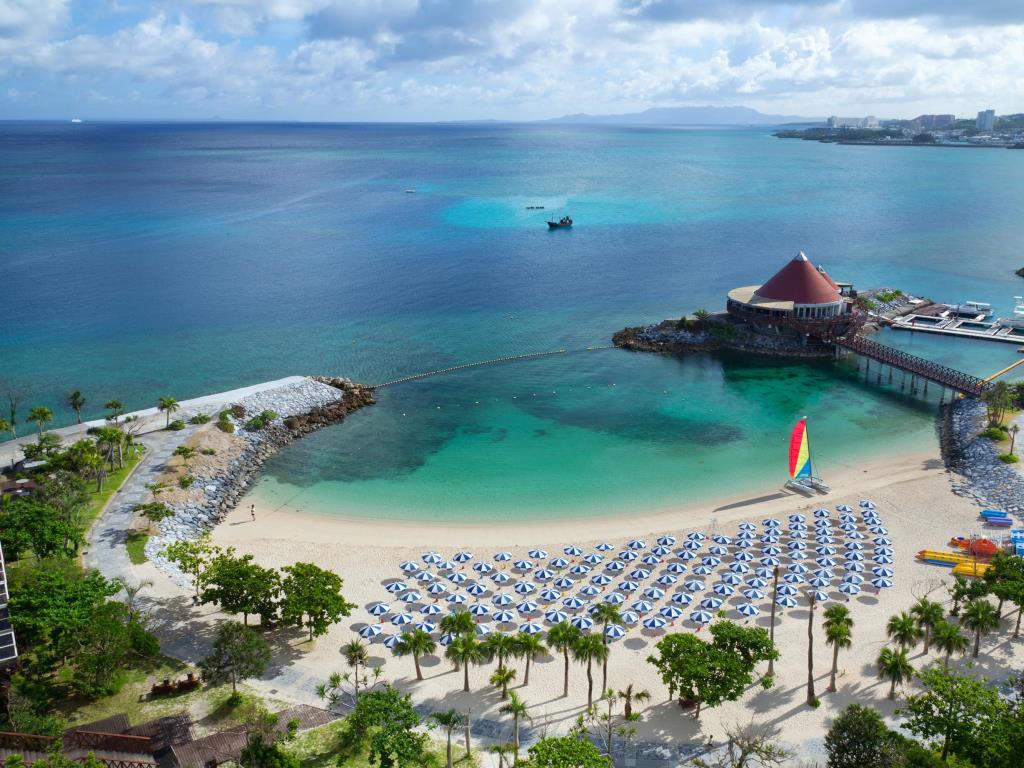 top view of resort, beach and umbrellas, green water