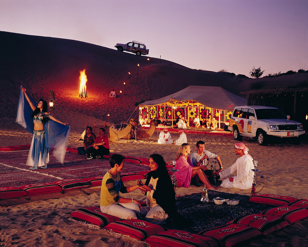 eating at night in desert with tent in background