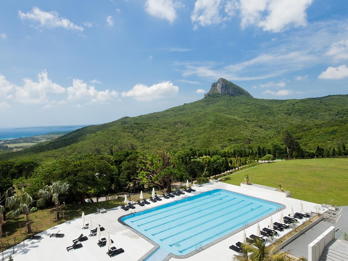 blue swimming pool, green lush mountains