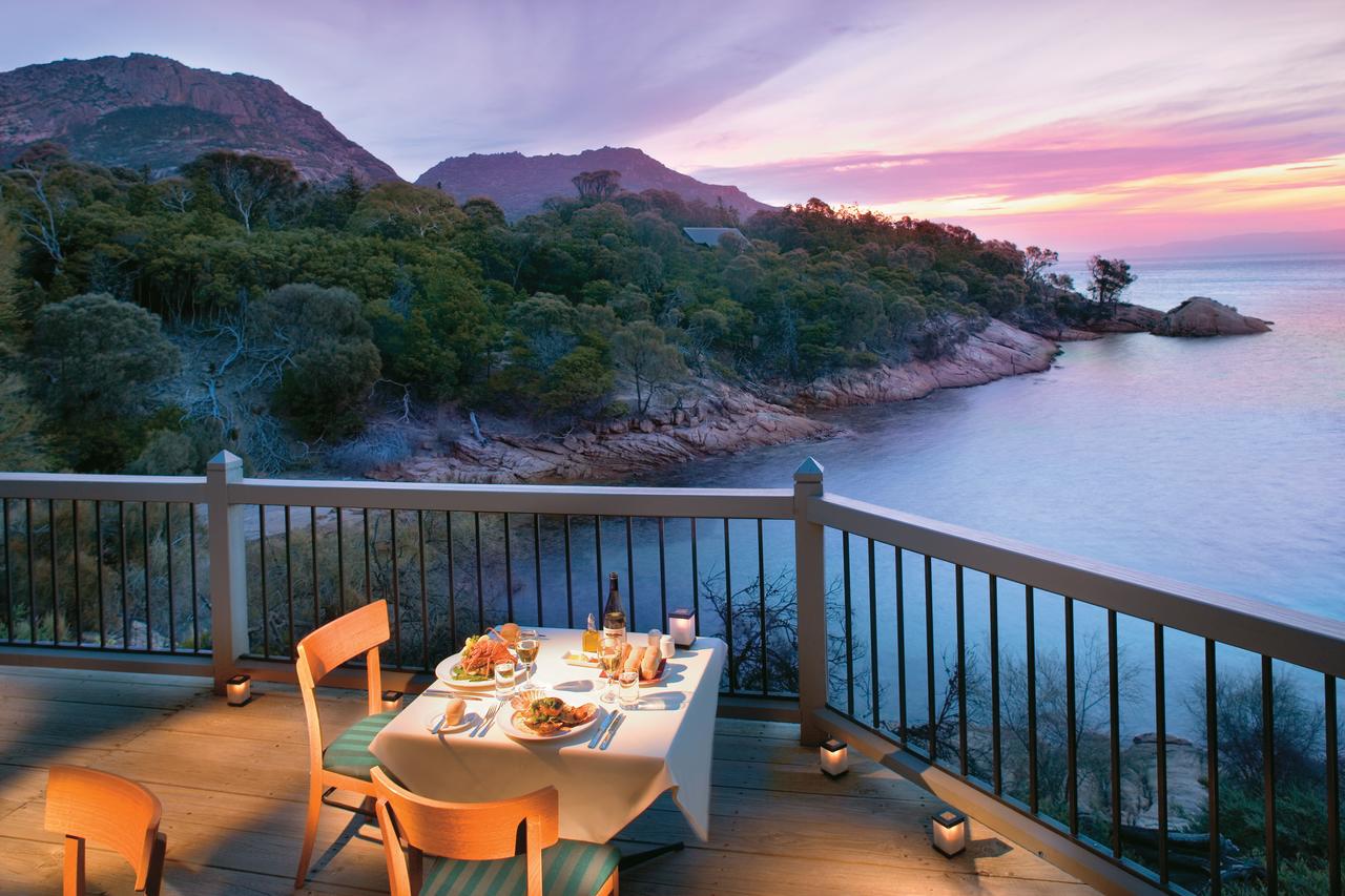 dining balcony, pink sunset, water and hills
