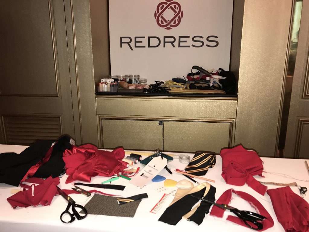 table with cloth swatches and scissors, Redress sign behind the table