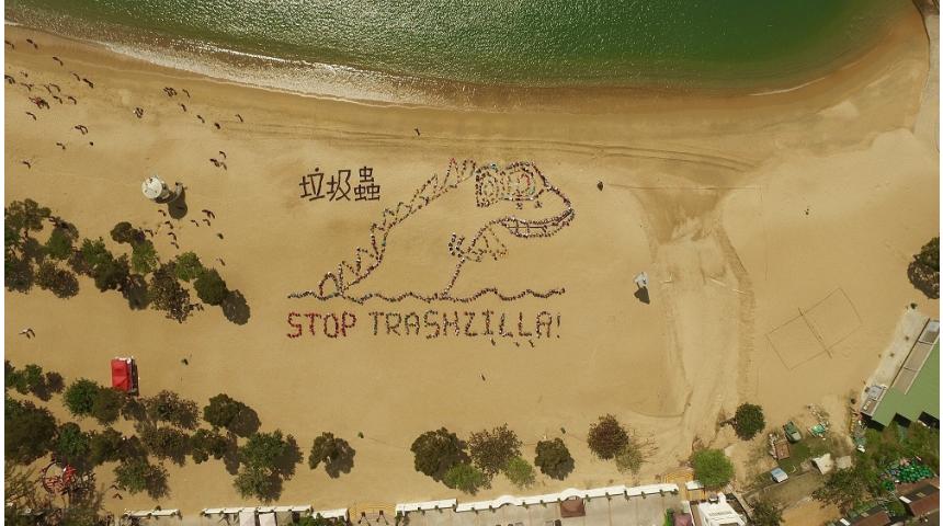 students on sand spell out "Stop Trashzilla" 