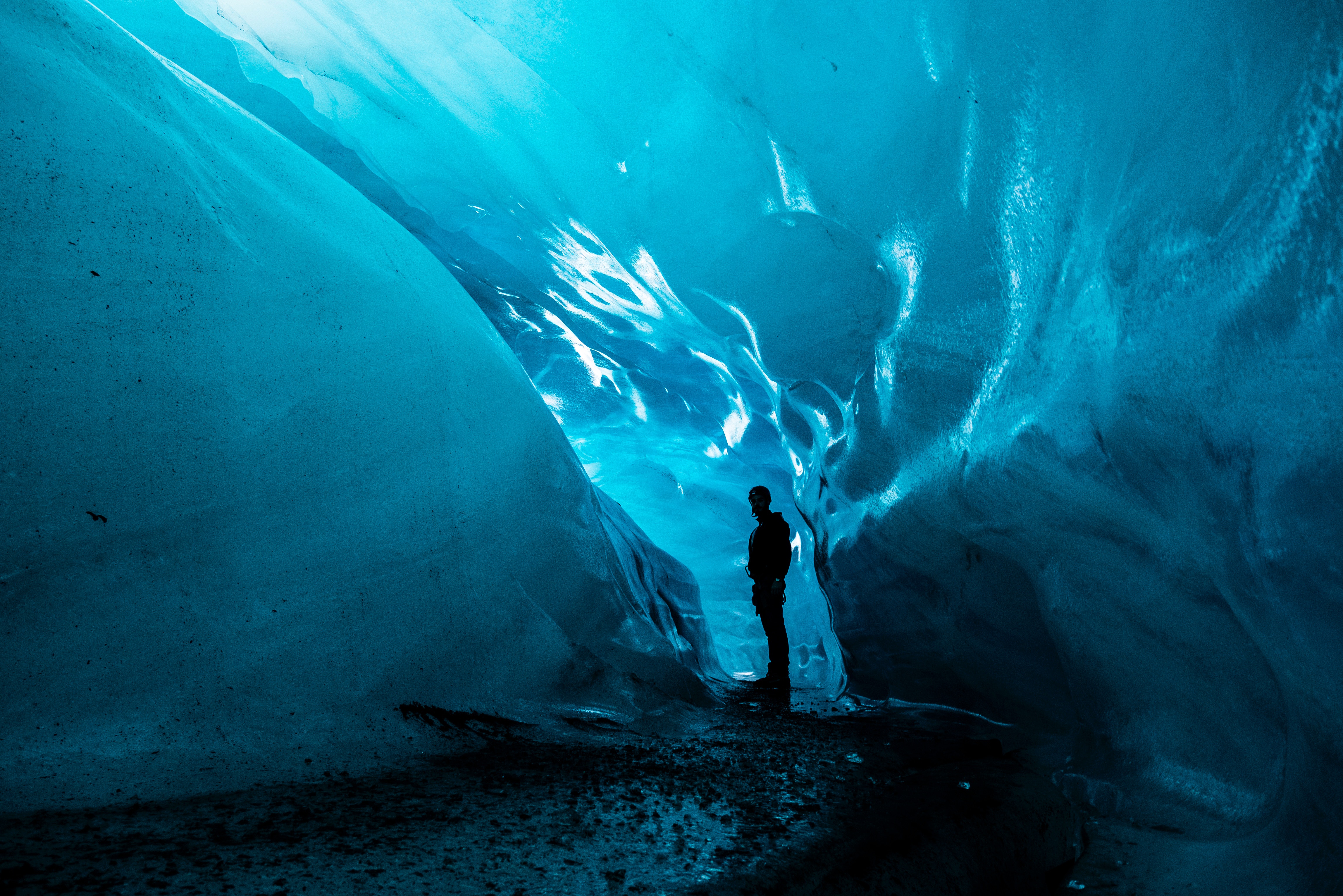 man in icy blue natural ice cave