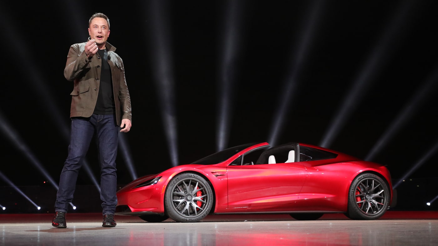 Elon Musk and cherry red Tesla Roadster