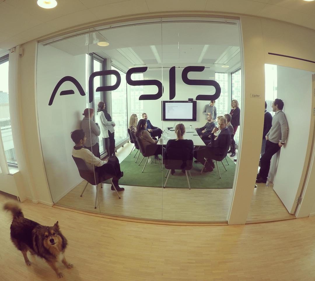 group of people in conference room with APSIS logo on door