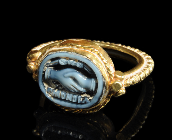 gold ring with hands clasped in the middle as design