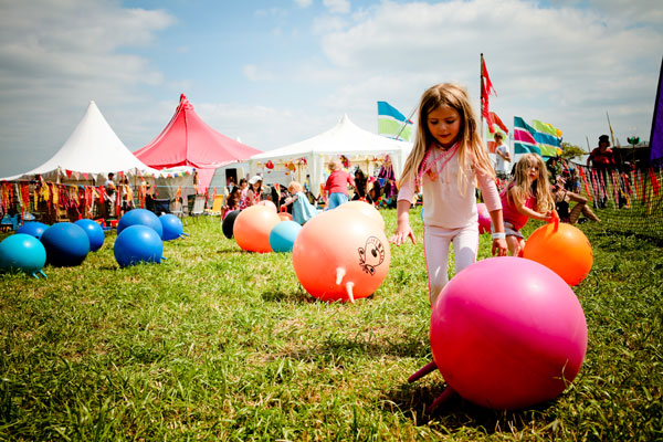 tents, girl on grass with colourful balls