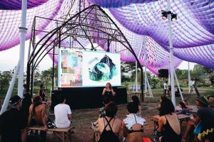 purple tent, audience on benches, presentation
