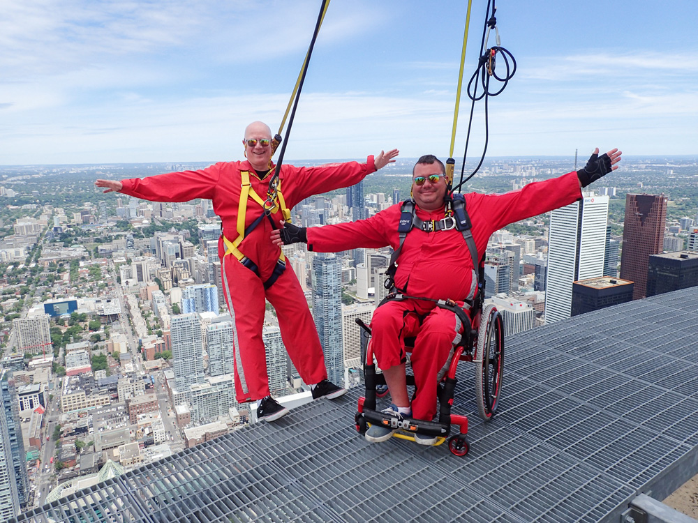 two men in red suits on Edgewalk, CN Tower, one in wheelchair