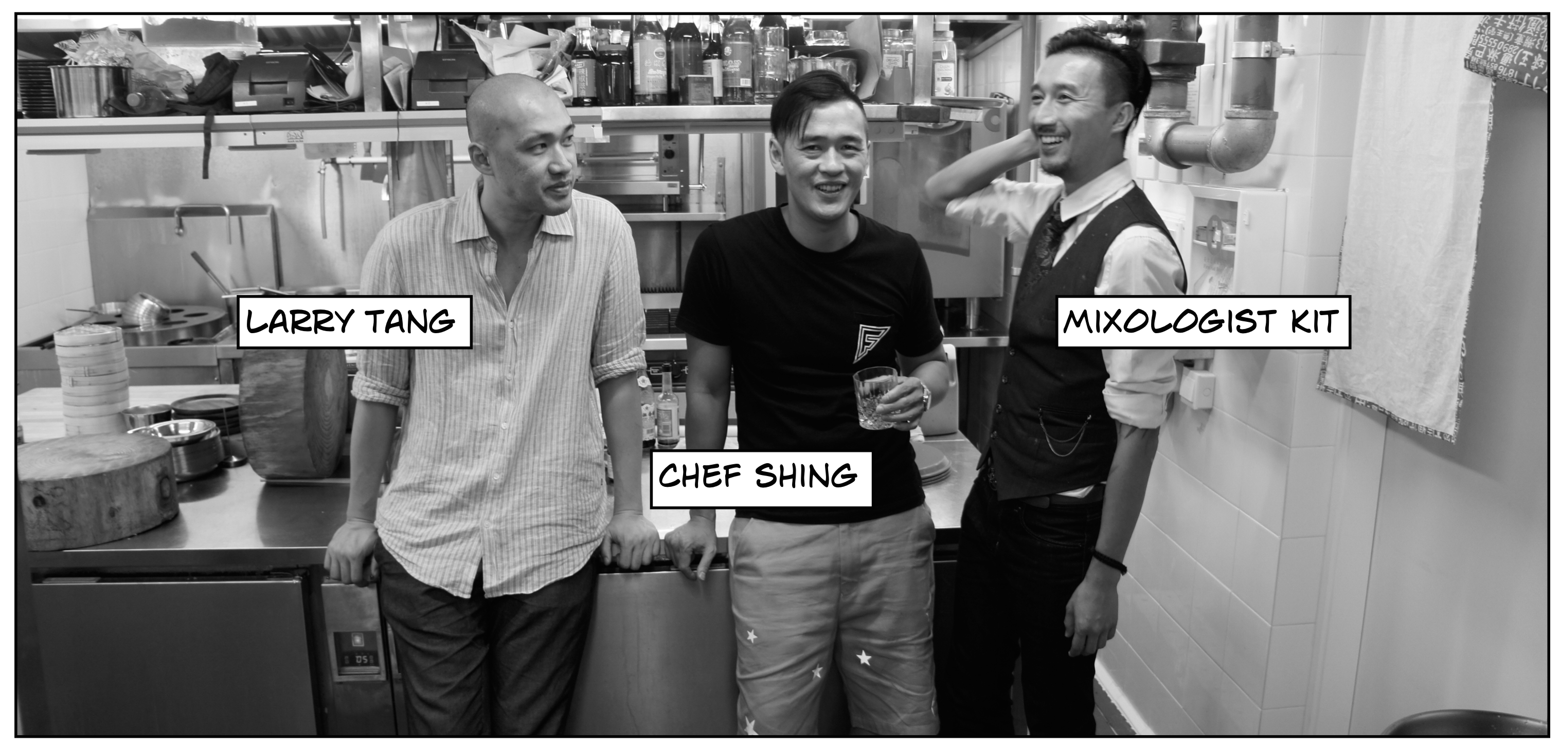 black and white photo of three men standing against a kitchen counter