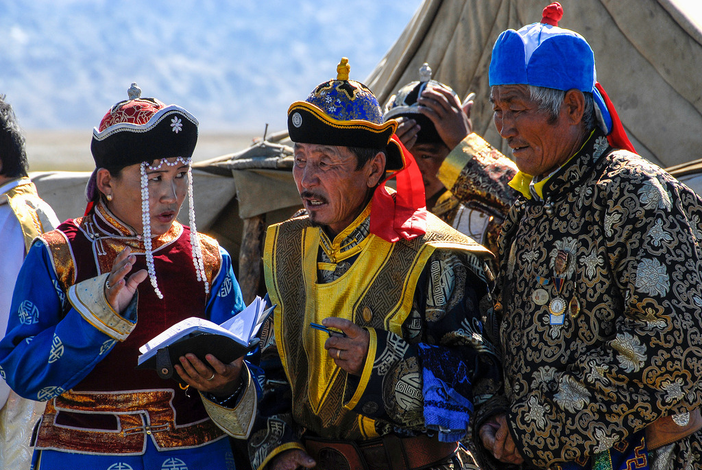 four men dressed in colourful Mongolian outfits and hats