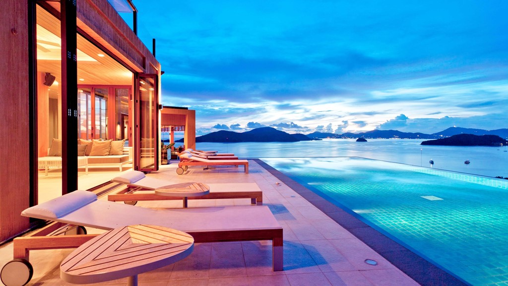 pool villa at dusk, overlooking blue infinity pool