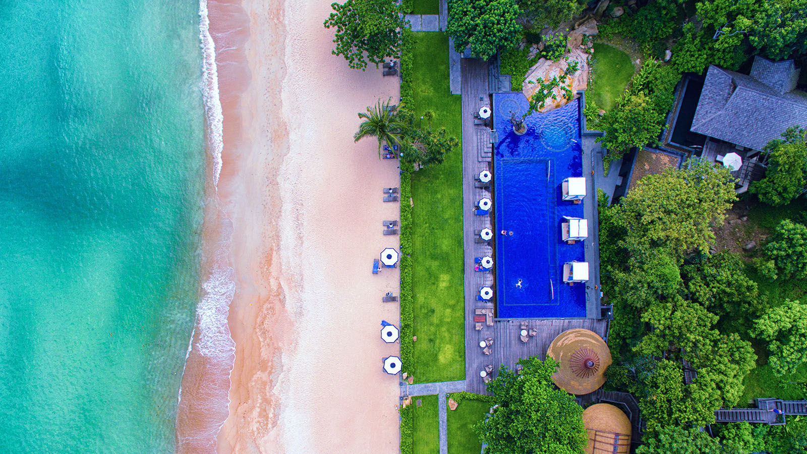 aerial view of beachfront hotel with bright blue infinity pool