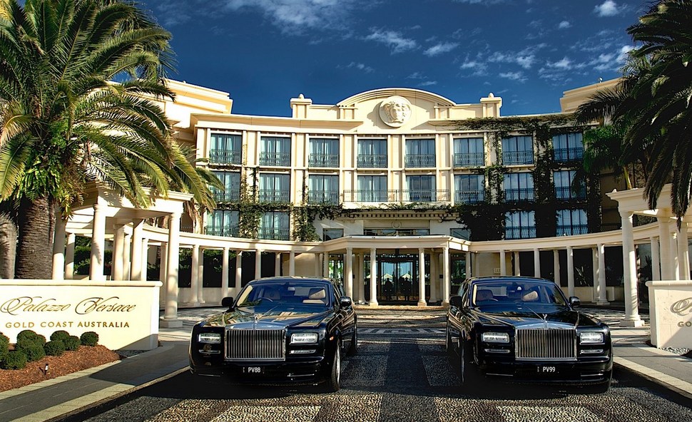large hotel, two black Rolls Royce cars