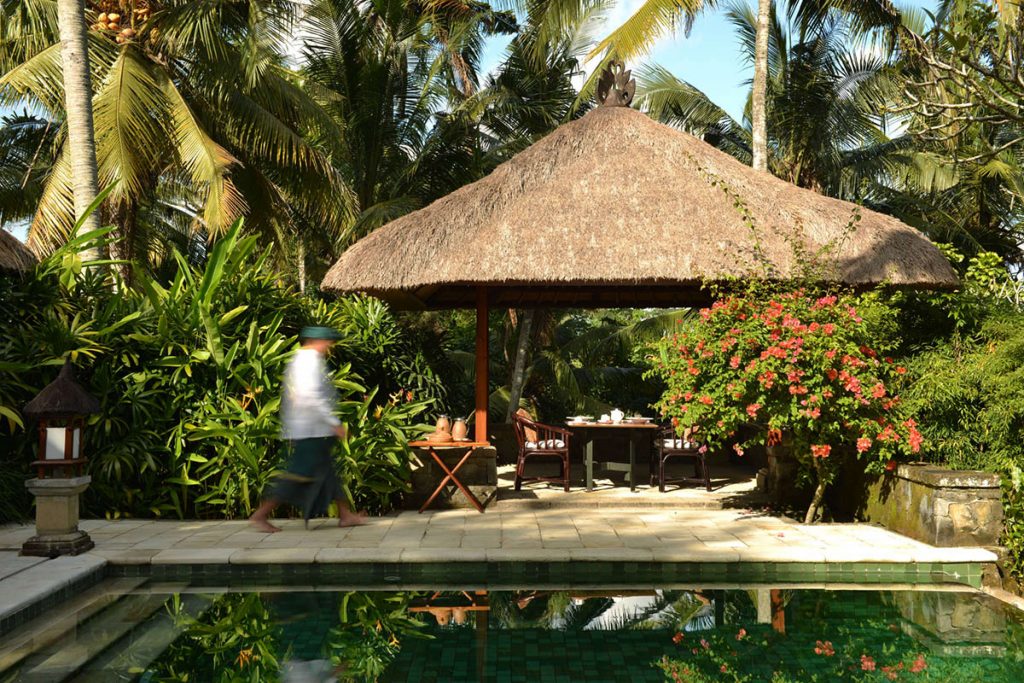 thatched hut, person walking, private pool