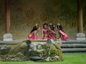 four girls in pink Indonesian costumes, kneeling 
