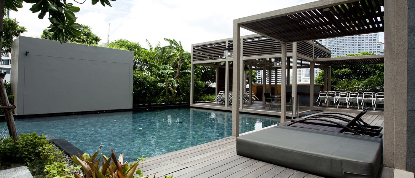infinity pool, wooden lounging sofas