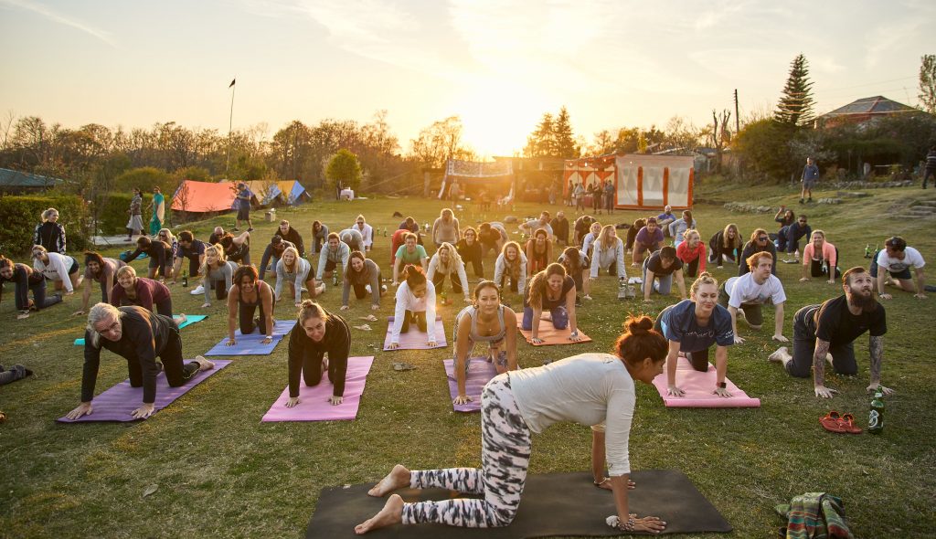 people doing yoga outside, sun setting