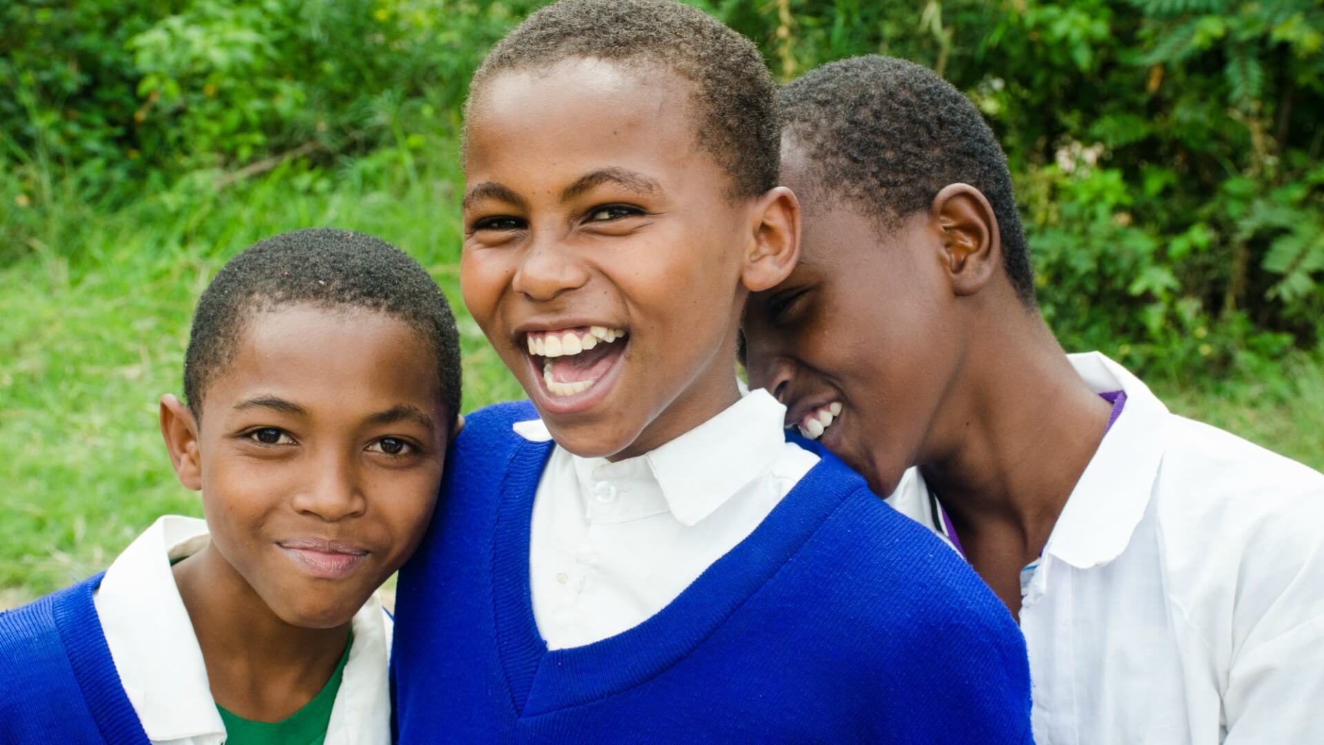 three dark skinned girls, blue sweater, smiling