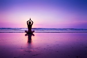 pink sunset, person cross legged in yoga pose