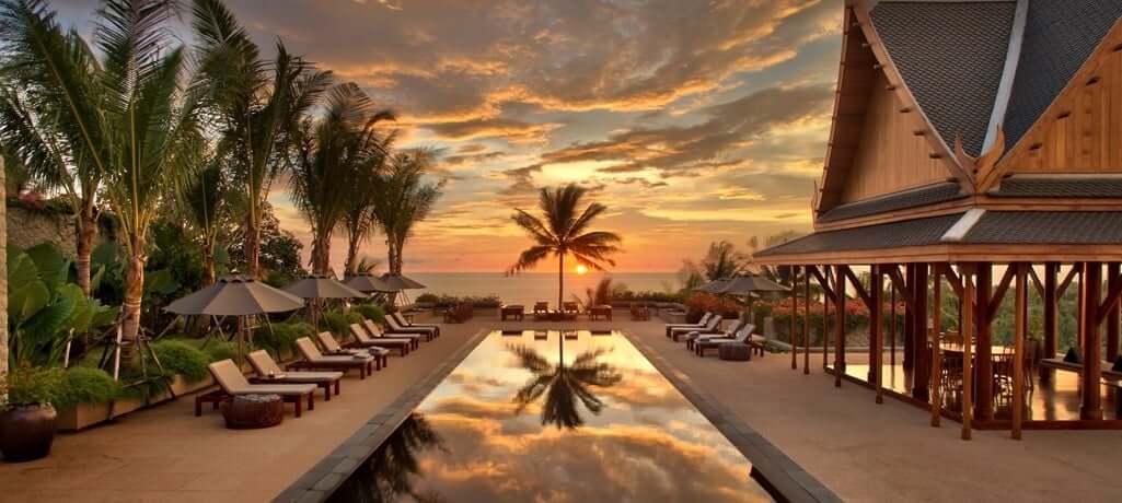 sunset over private villa pool, palm trees