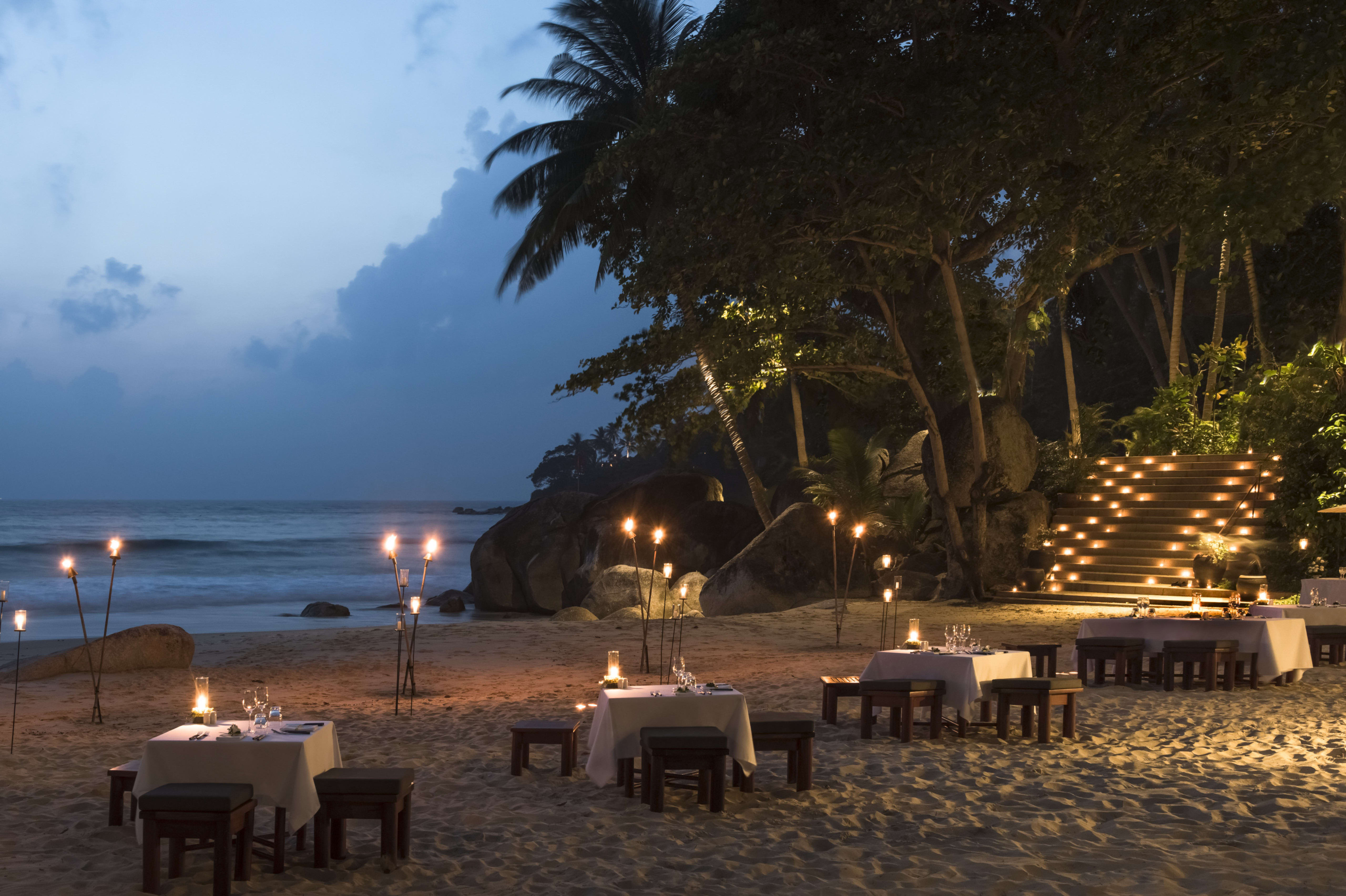 white tablecloth tables on beach, sunset