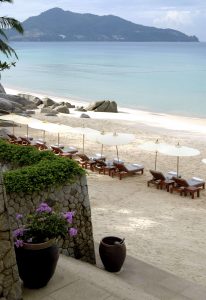 beach loungers and umbrellas on white sand beach